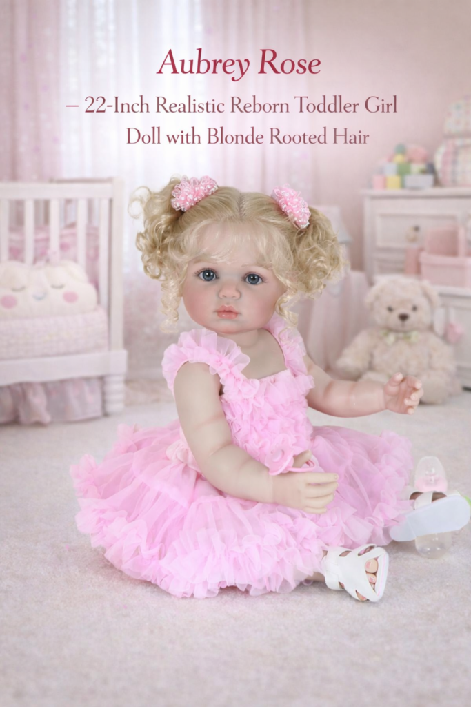 Aubrey Rose 22-inch realistic reborn toddler girl sitting in a pink nursery with a crib and teddy bear
