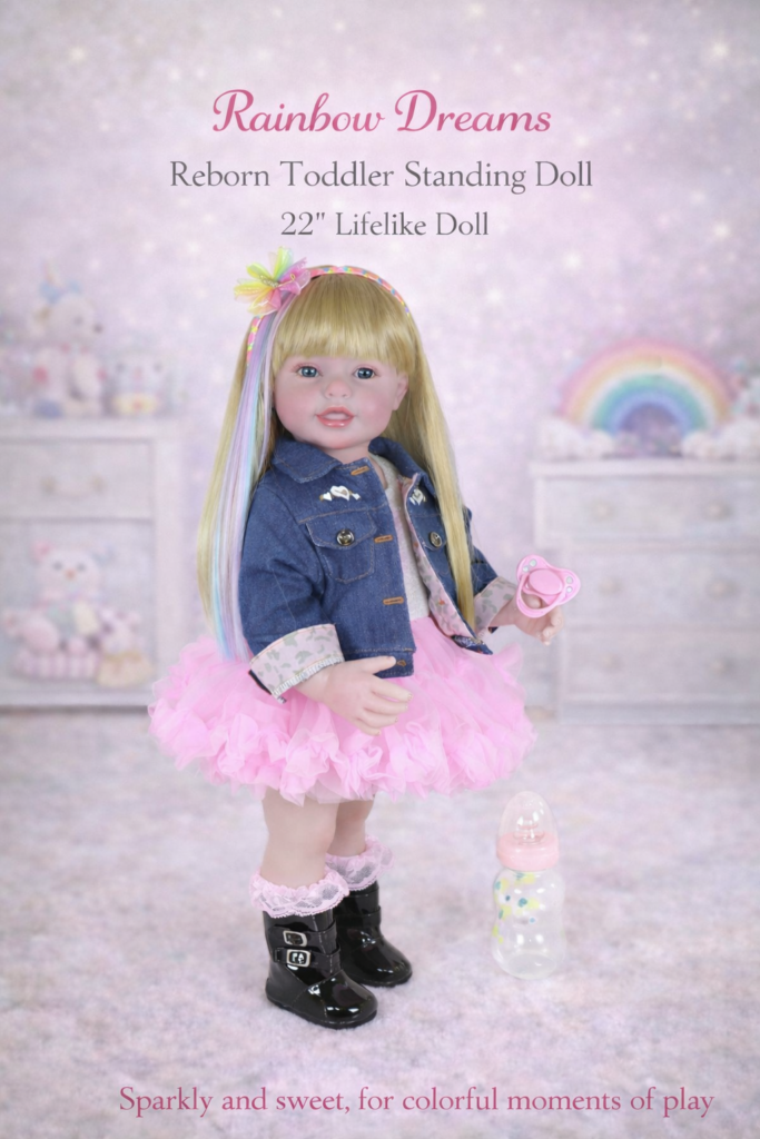 Enchanting Rainbow Dreams 22-inch reborn toddler doll standing in a rainbow-themed room wearing a denim jacket pink tutu dress and pink bow
