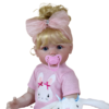 Ellie Mae toddler doll close-up with blonde hair, pink bow headband, and pacifier