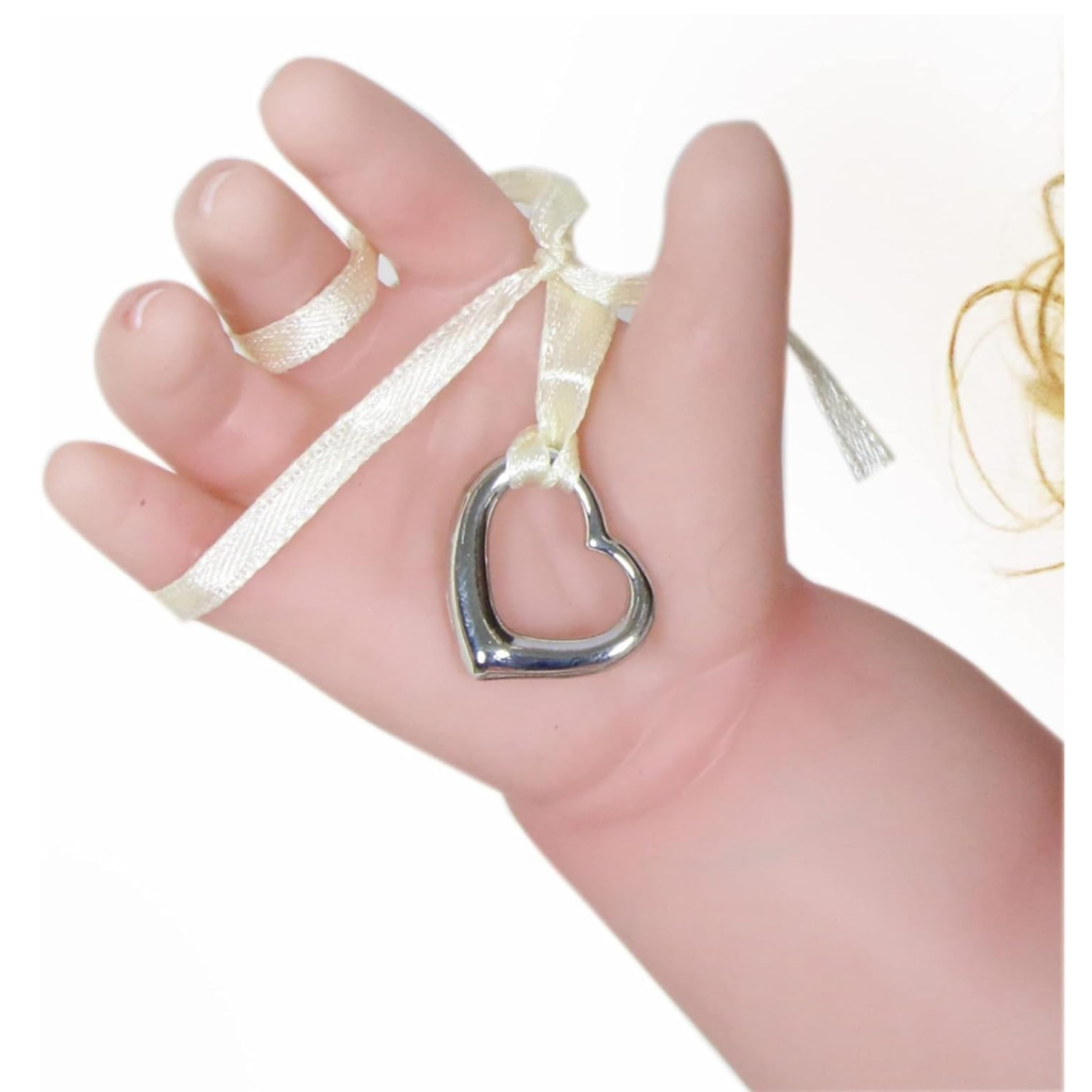 Close-up reborn doll hand holding heart pendant necklace accessory for Happy Birthday Girl doll