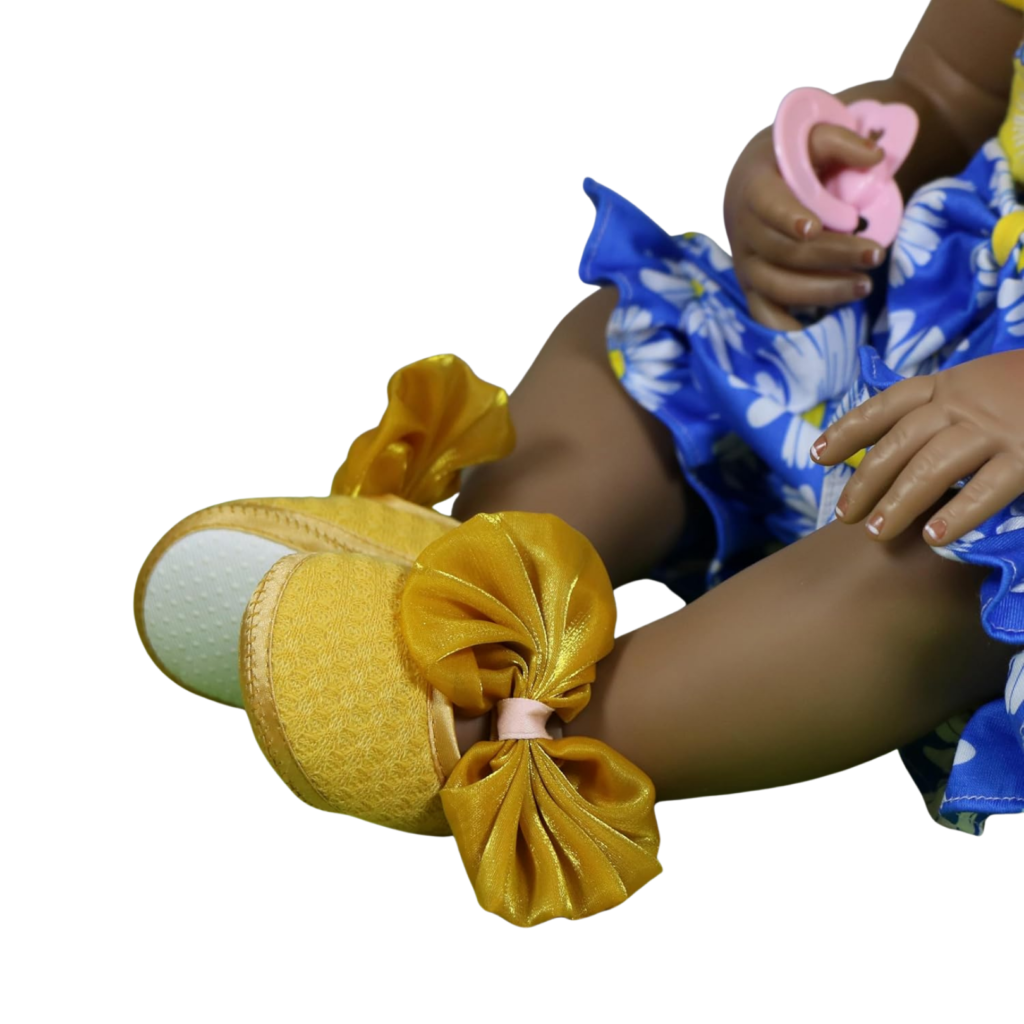 Sweet Sunshine Daisy doll detail showing yellow bow shoes and hand holding pink pacifier
