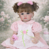 Clara Bloom reborn toddler doll in floral garden backdrop wearing lace dress and holding pink pacifier