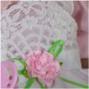 Clara Bloom reborn doll dress detail with white lace overlay pink ribbon rose and delicate floral accents