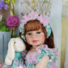 lifelike reborn toddler doll close up with green eyes holding plush bunny