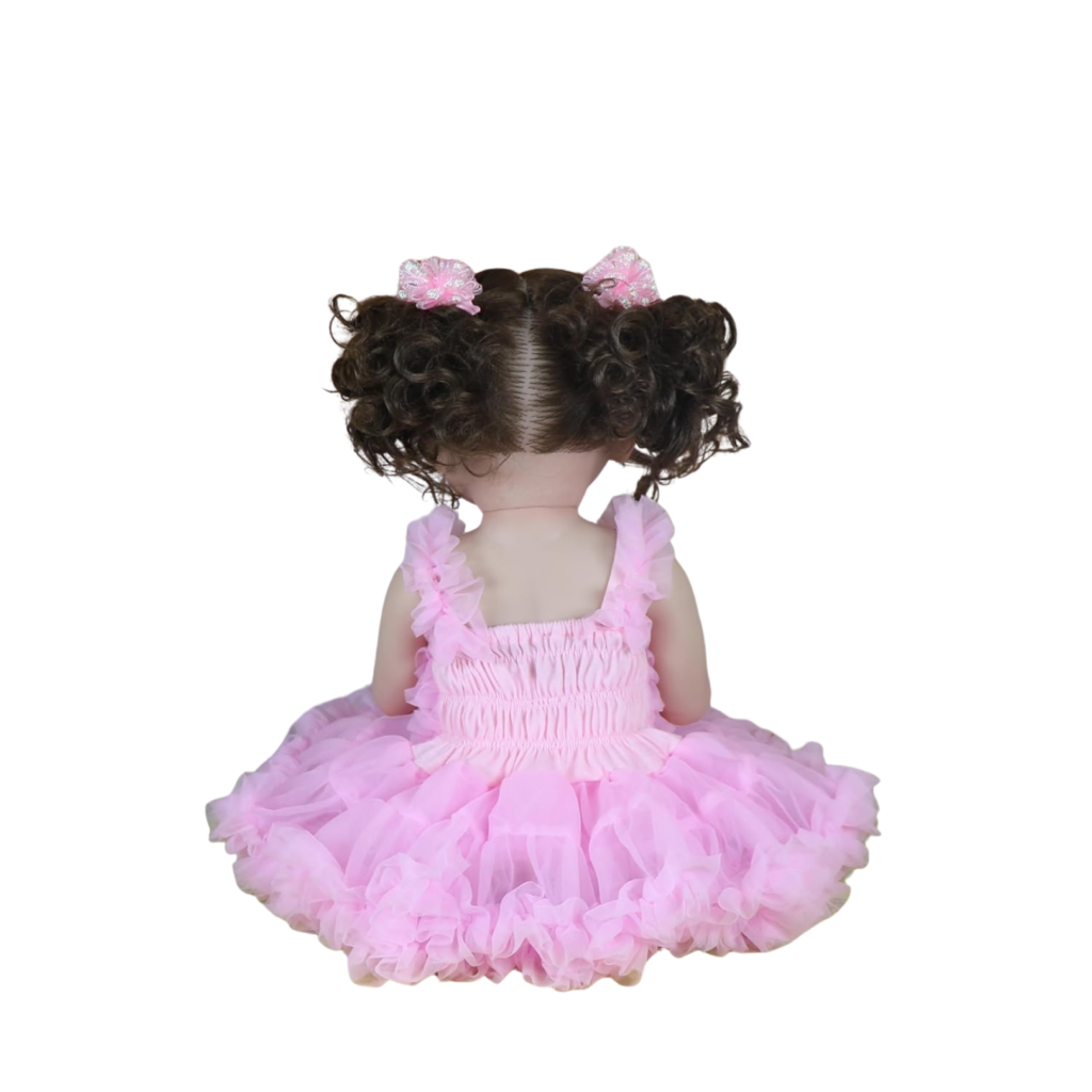 Back view of Madison reborn doll showing curly pigtails and pink ruffle dress design