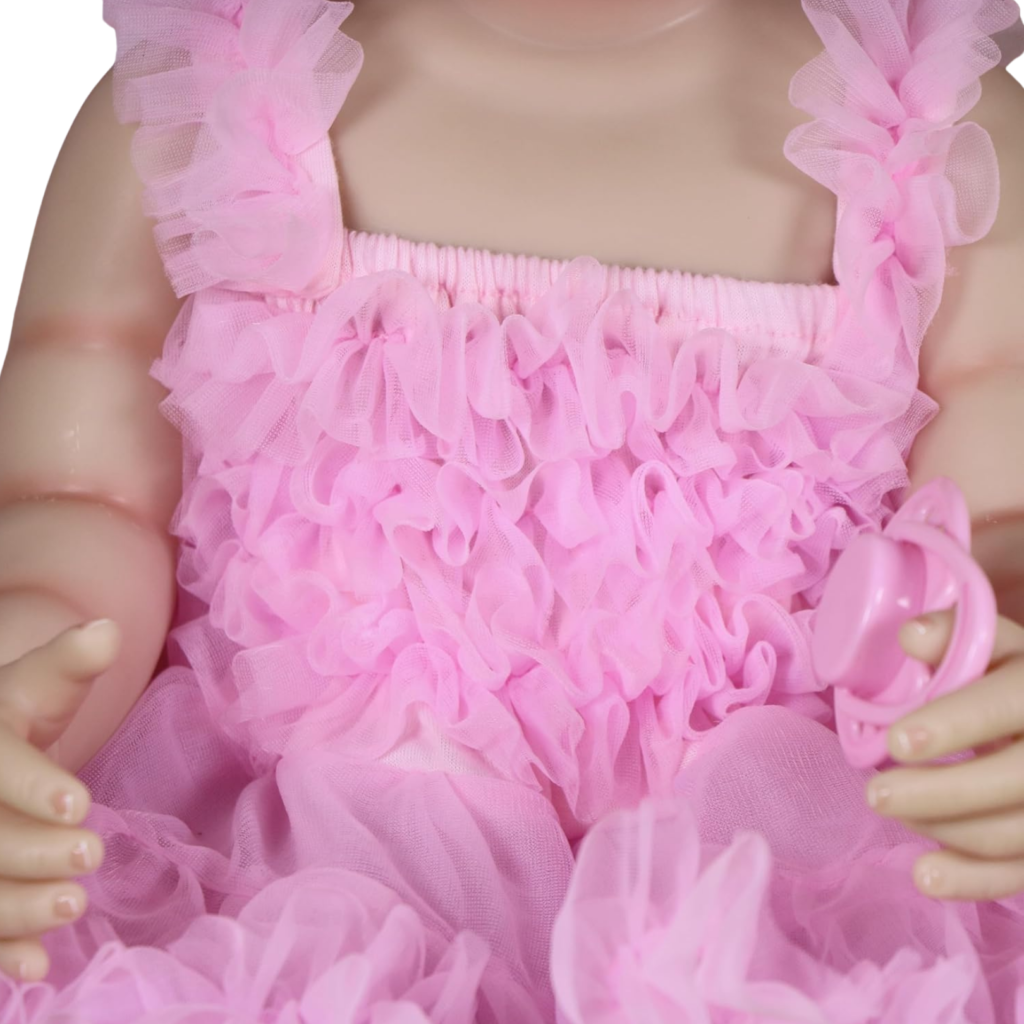 Close-up of pink ruffle party dress on reborn toddler doll with soft layered fabric