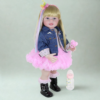 Rainbow Dreams reborn toddler doll with long blonde hair rainbow streak and pink tutu dress posing with bottle