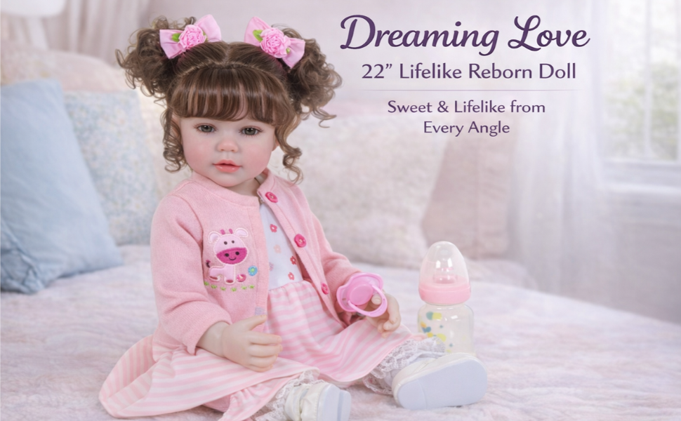 Dreaming Love 22 inch toddler doll in pink dress with curly hair sitting on bed with accessories