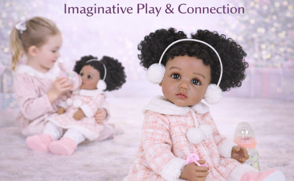 Snowy Poms African American reborn toddler doll wearing pink winter coat and earmuffs sitting with pacifier and bottle
