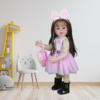 realistic reborn toddler doll standing in nursery with pink dress and bow headband