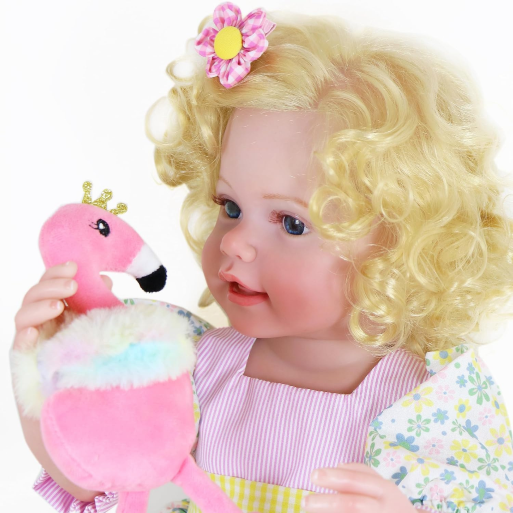 close up Sunny Flamingo Girl reborn doll face with blue eyes blonde curls holding flamingo plush toy
