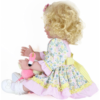 side view of Sunny Flamingo Girl reborn toddler doll with blonde curls holding pink flamingo plush wearing floral dress