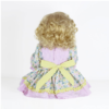 Sunny Flamingo Girl reborn doll back view showing curly blonde hair floral dress with yellow bow and detailed outfit design