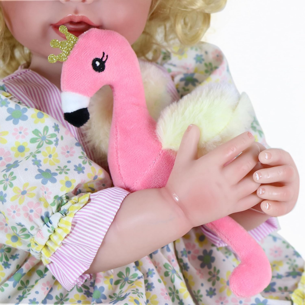 close up reborn doll hands holding flamingo plush showing realistic skin details and floral outfit