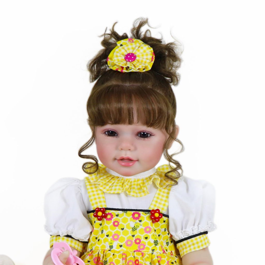 Close-up Bella Sunshine reborn baby doll with brown hair curls yellow dress and lifelike facial features