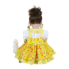 Back view Bella Sunshine reborn toddler doll showing yellow floral dress and detailed outfit design