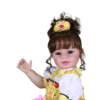 Bella Sunshine lifelike toddler doll with curly hair holding pacifier wearing bright yellow dress