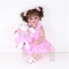 reborn toddler doll pink outfit with bunny toy and baby bottle white background