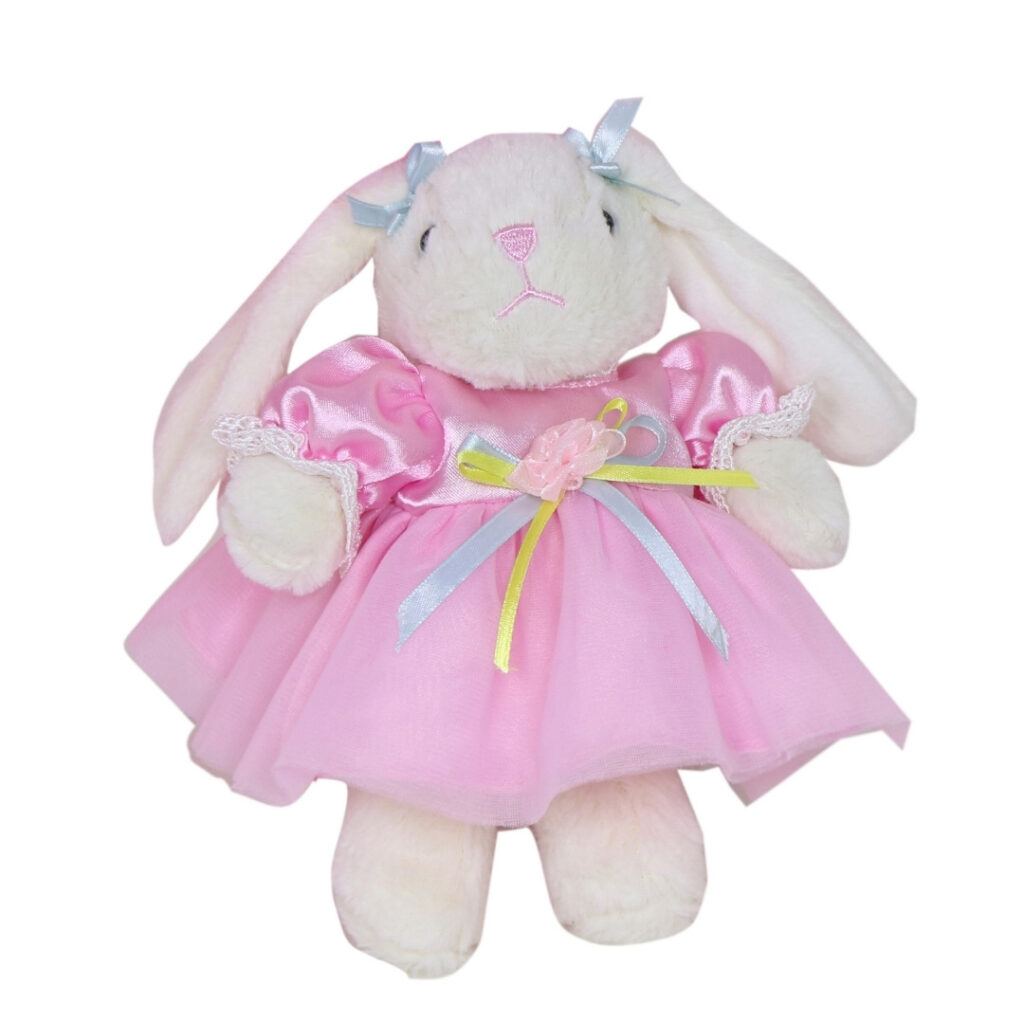 Pink doll party dress outfit with matching bloomers displayed beside plush bunny accessory
